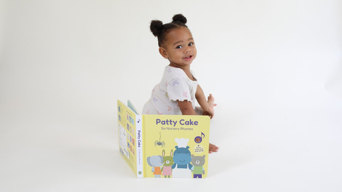 A toddler is sitting next to a musical picture book. Itsy bitsy spider lyrics, itsy bitsy spider song, nursery rhymes, musical books for kids.